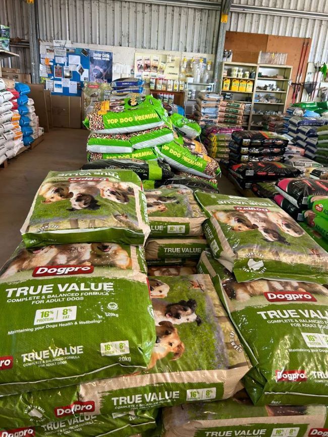 A Bunch of Bags of Dog Food Are Stacked on Top of Each Other — Barnyard Stockfeed, Pet, Garden and Florist in Childers, QLD
