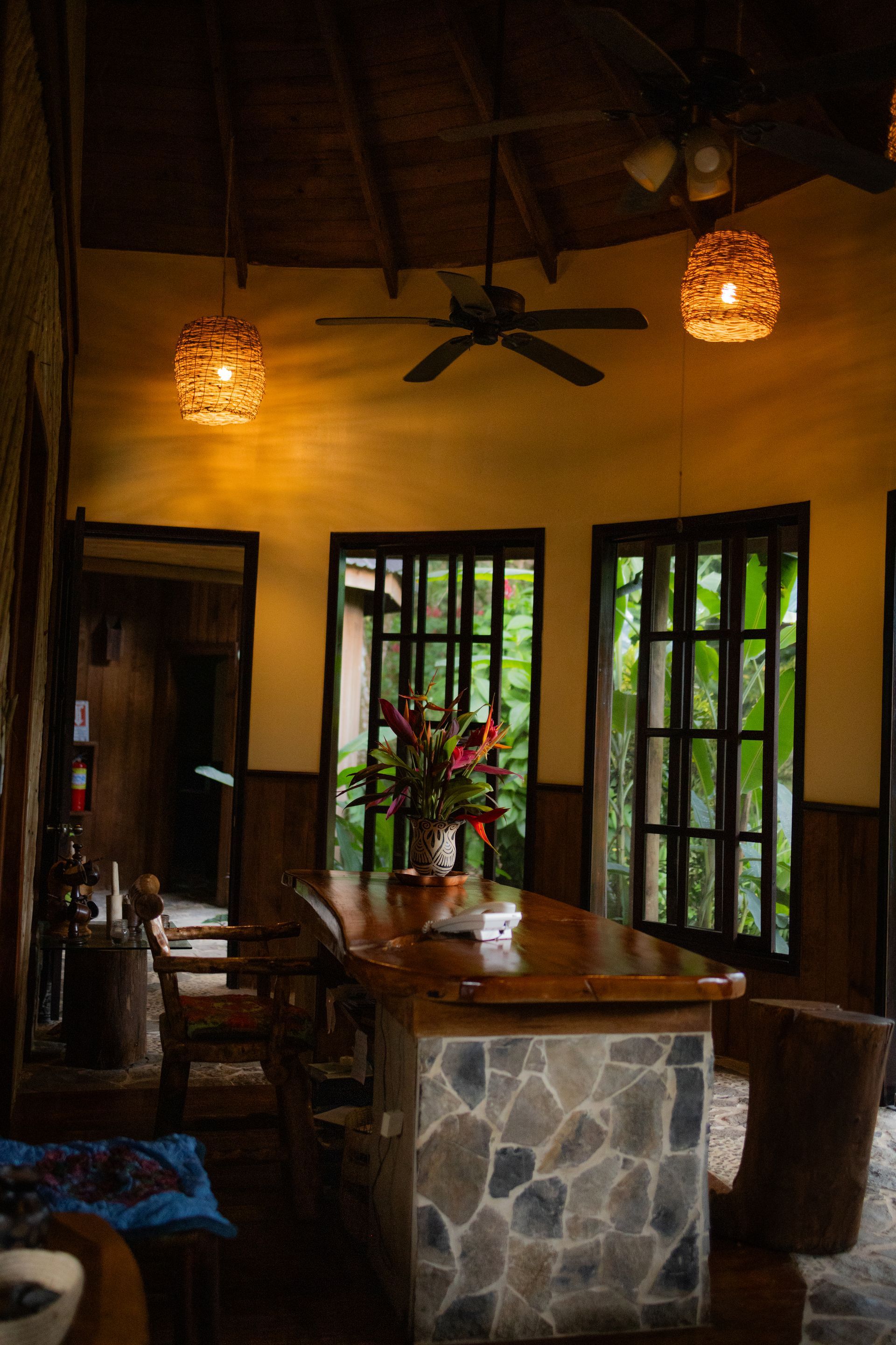 A living room with a table and chairs and a ceiling fan.