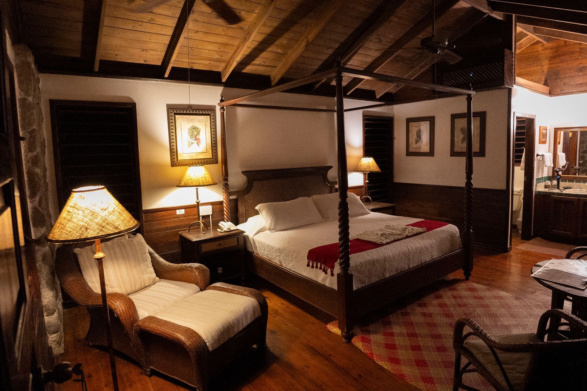 A bedroom with a four poster bed and a chair