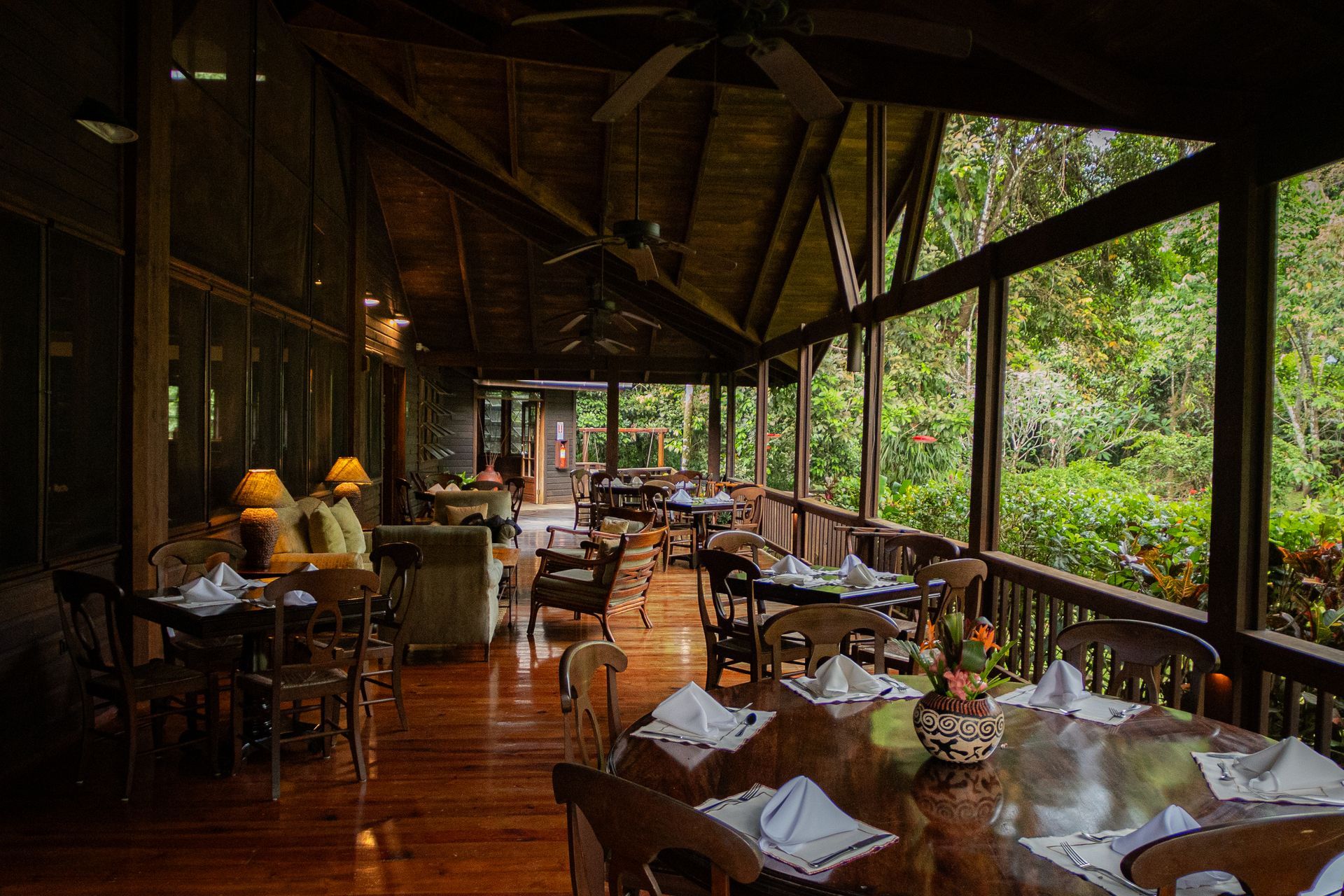 A restaurant with tables and chairs and a ceiling fan.
