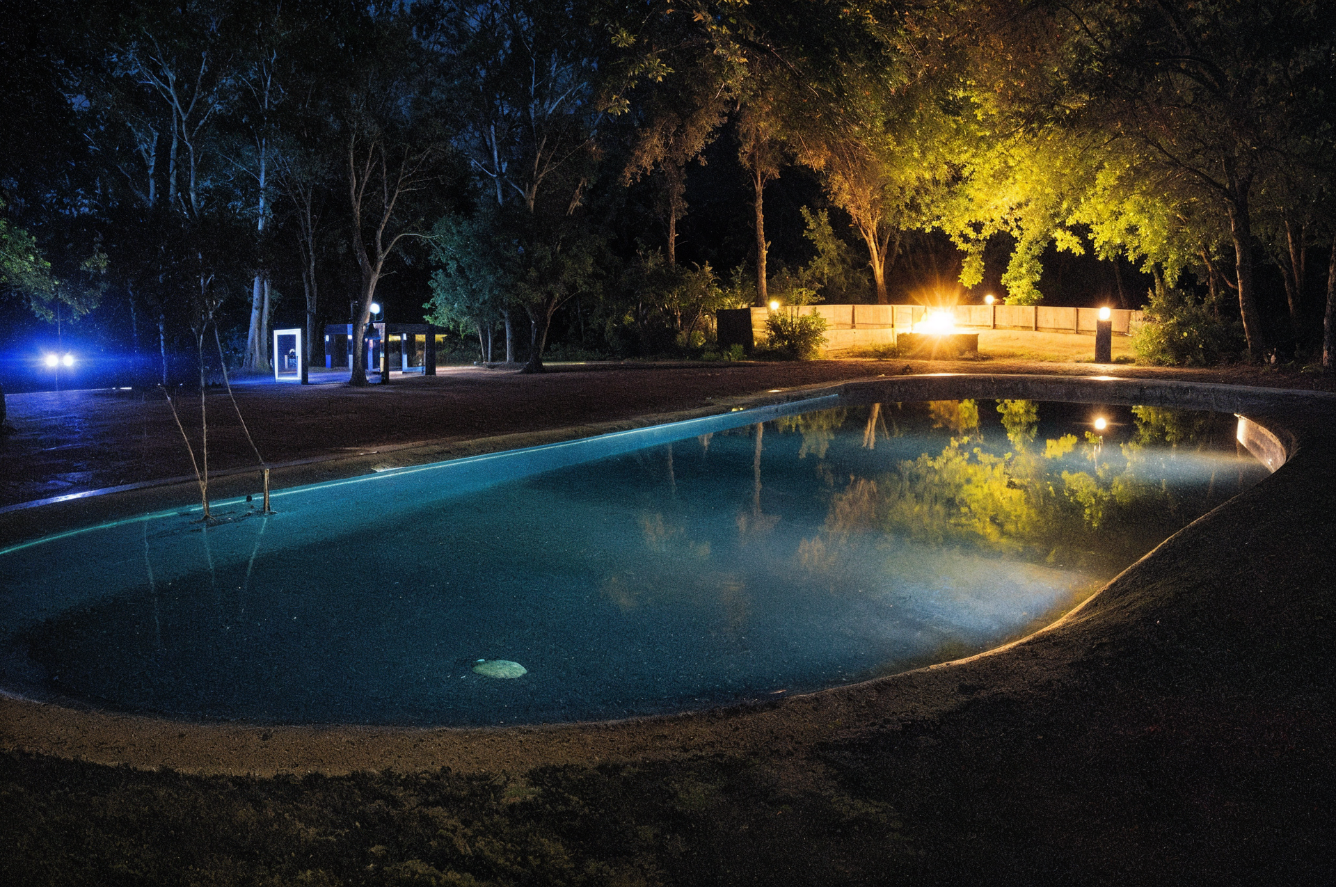 A large swimming pool is lit up at night