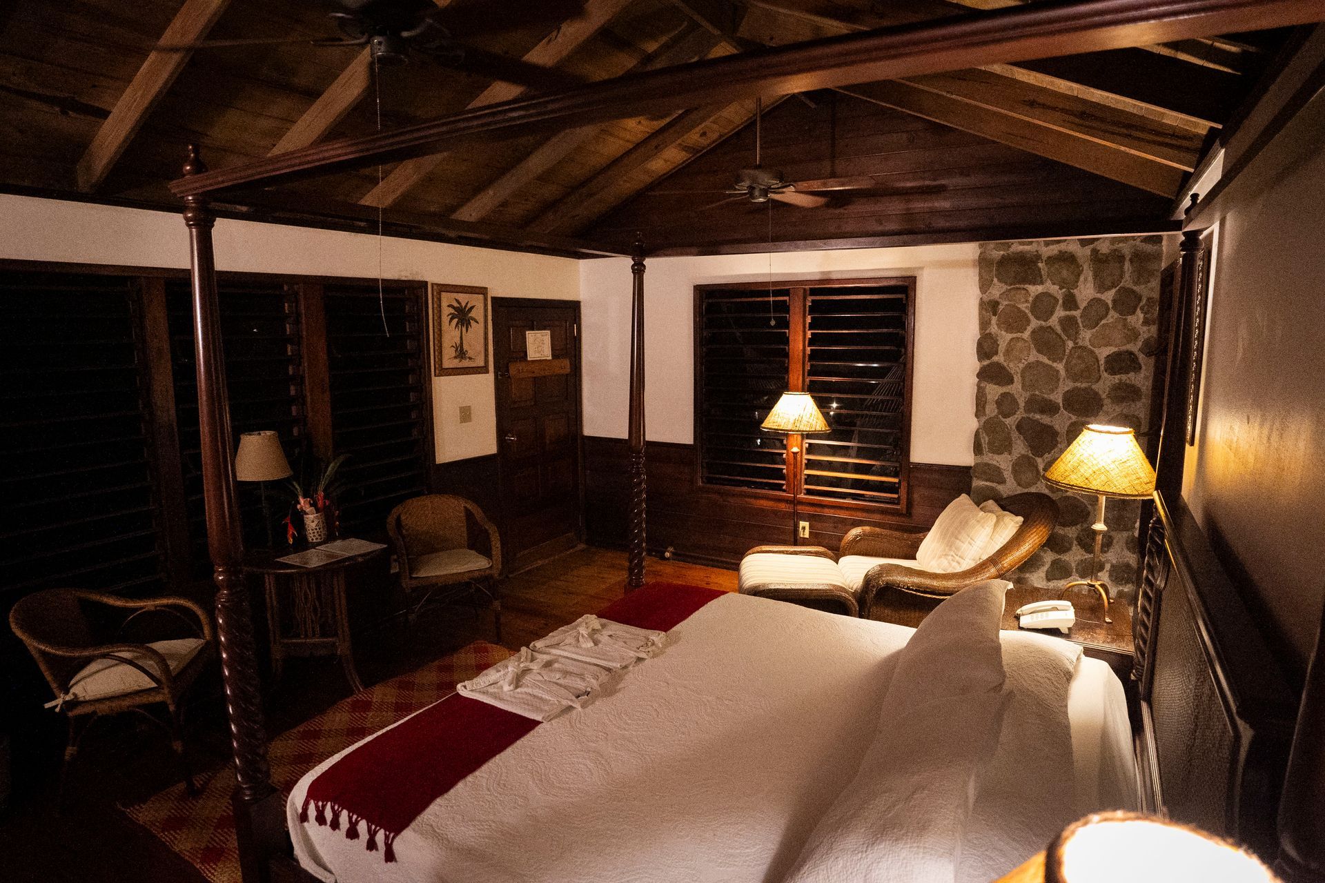 A bedroom with a four poster bed and a ceiling fan