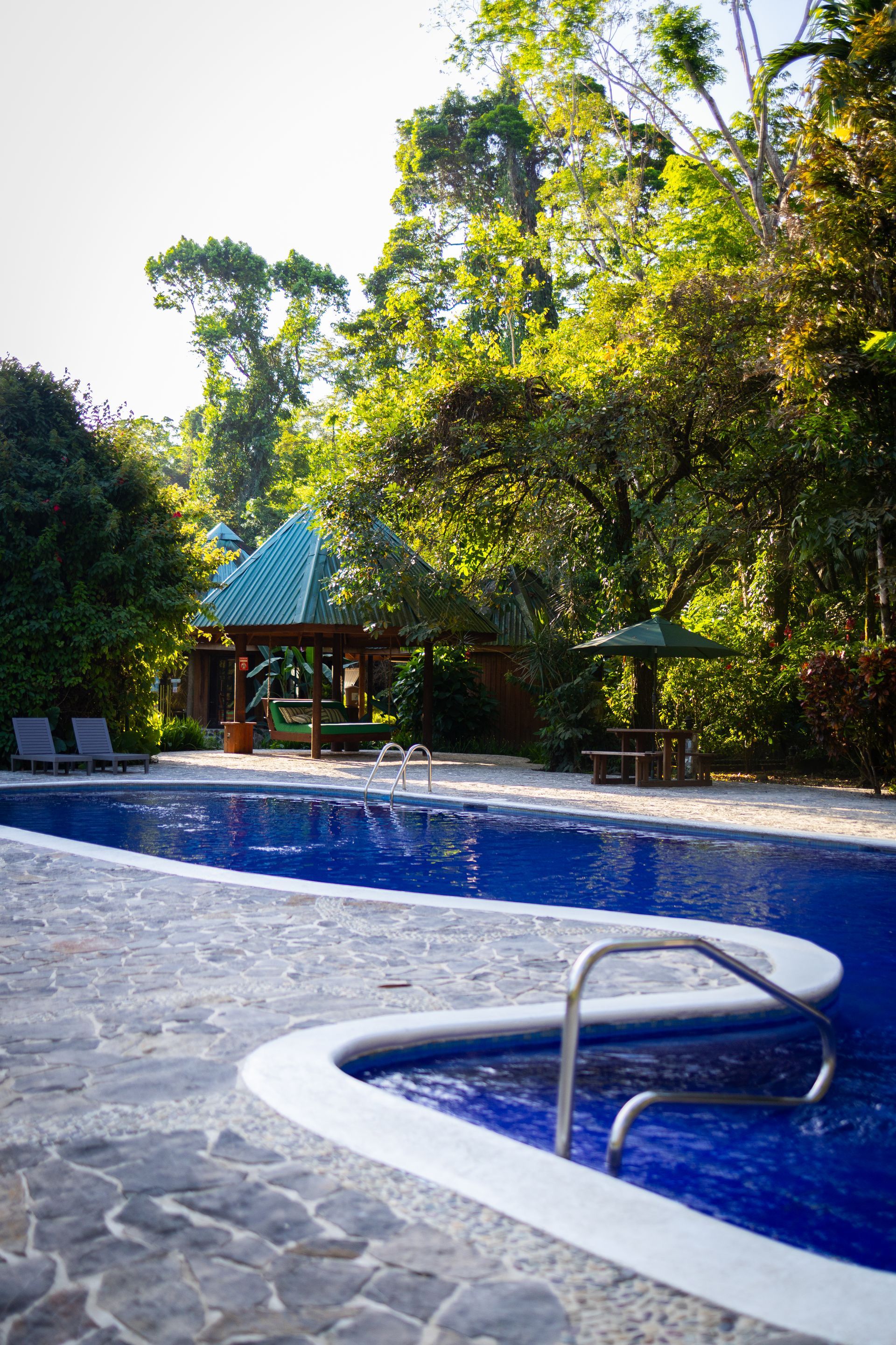 A large swimming pool with a gazebo in the background