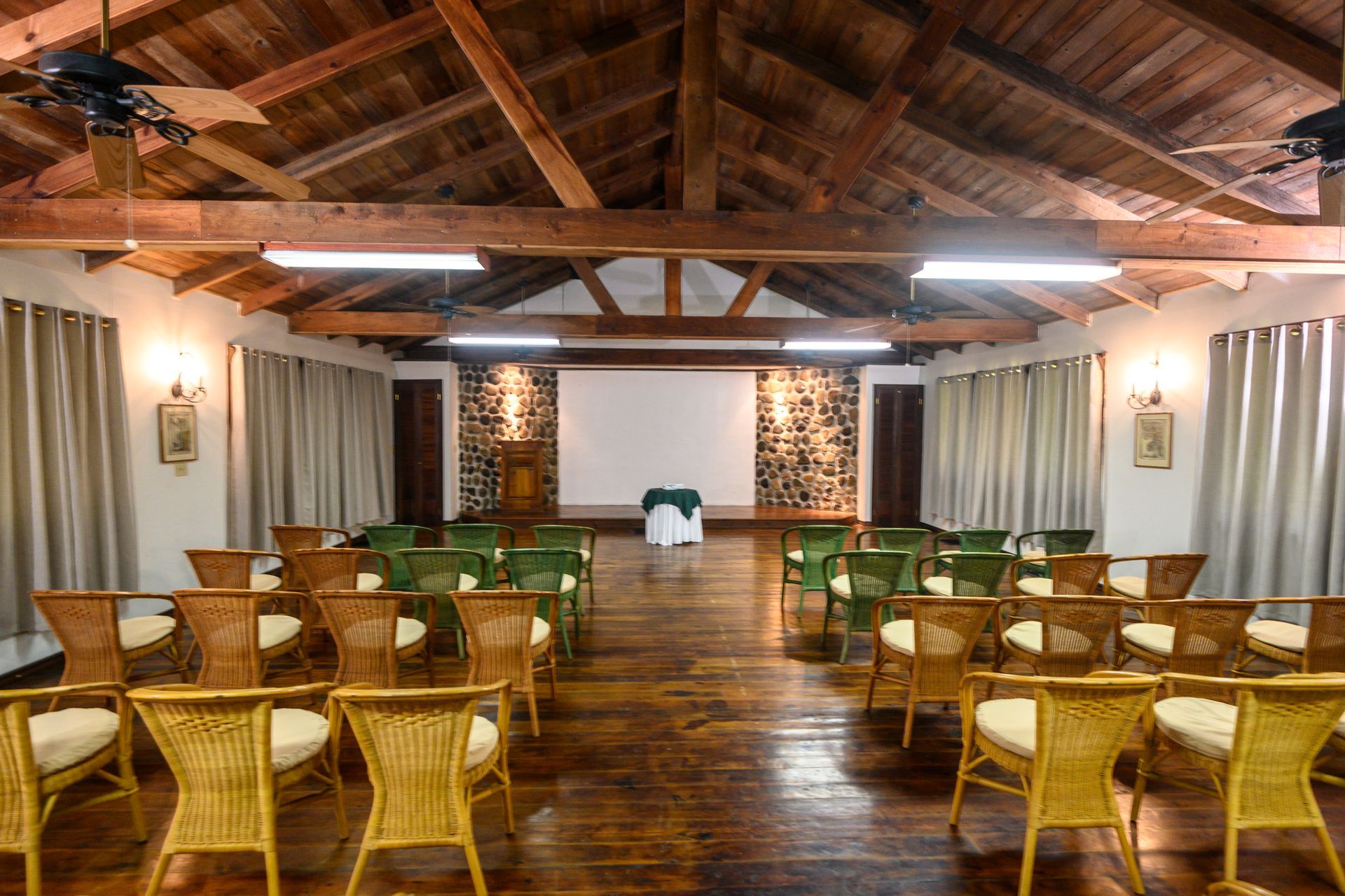 A large room filled with wicker chairs and a projector screen.