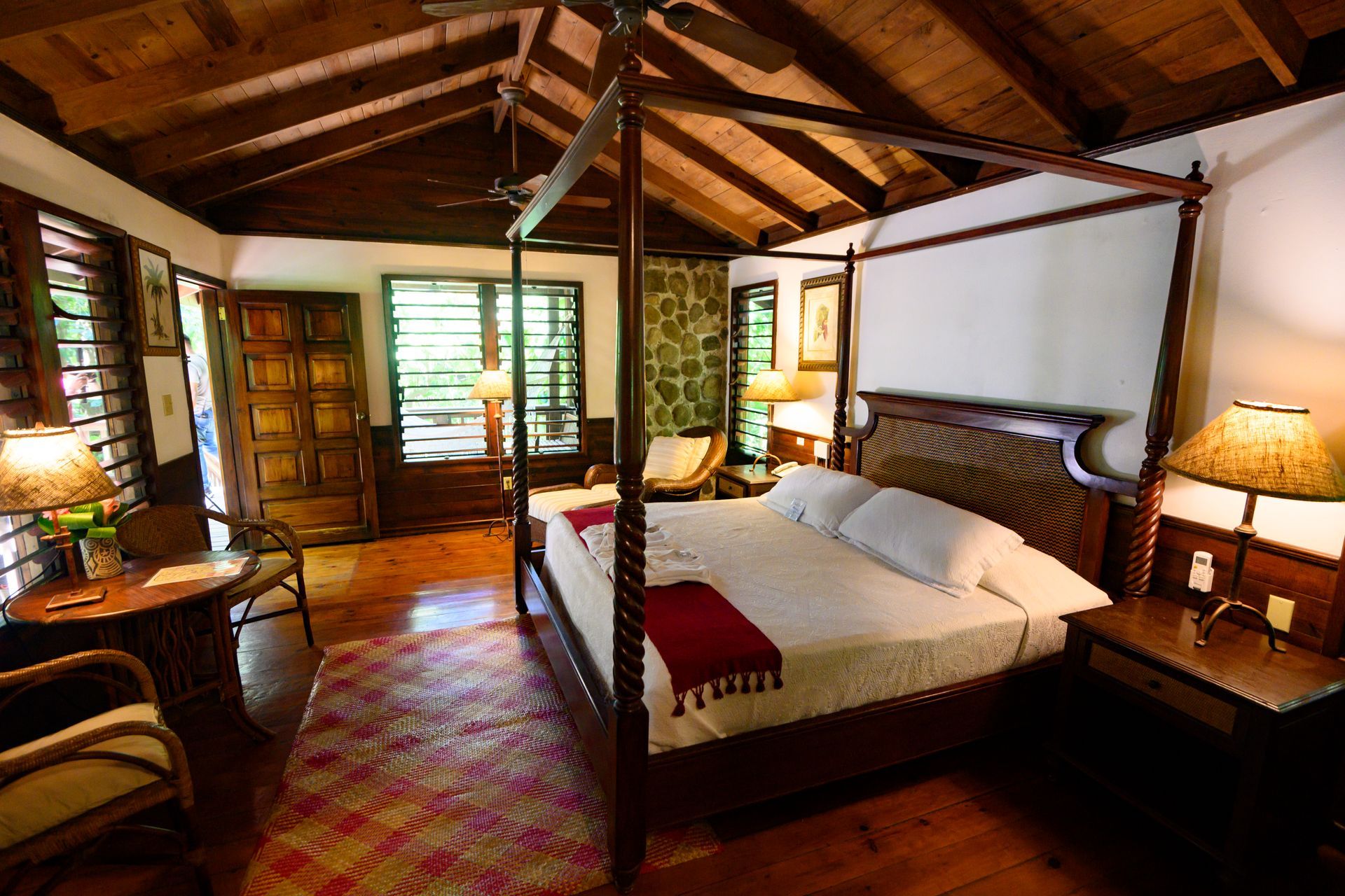 A bedroom with a four poster bed and a wooden ceiling