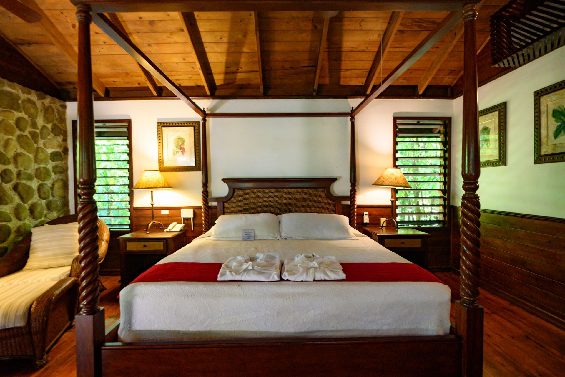A bedroom with a four poster bed and a couch