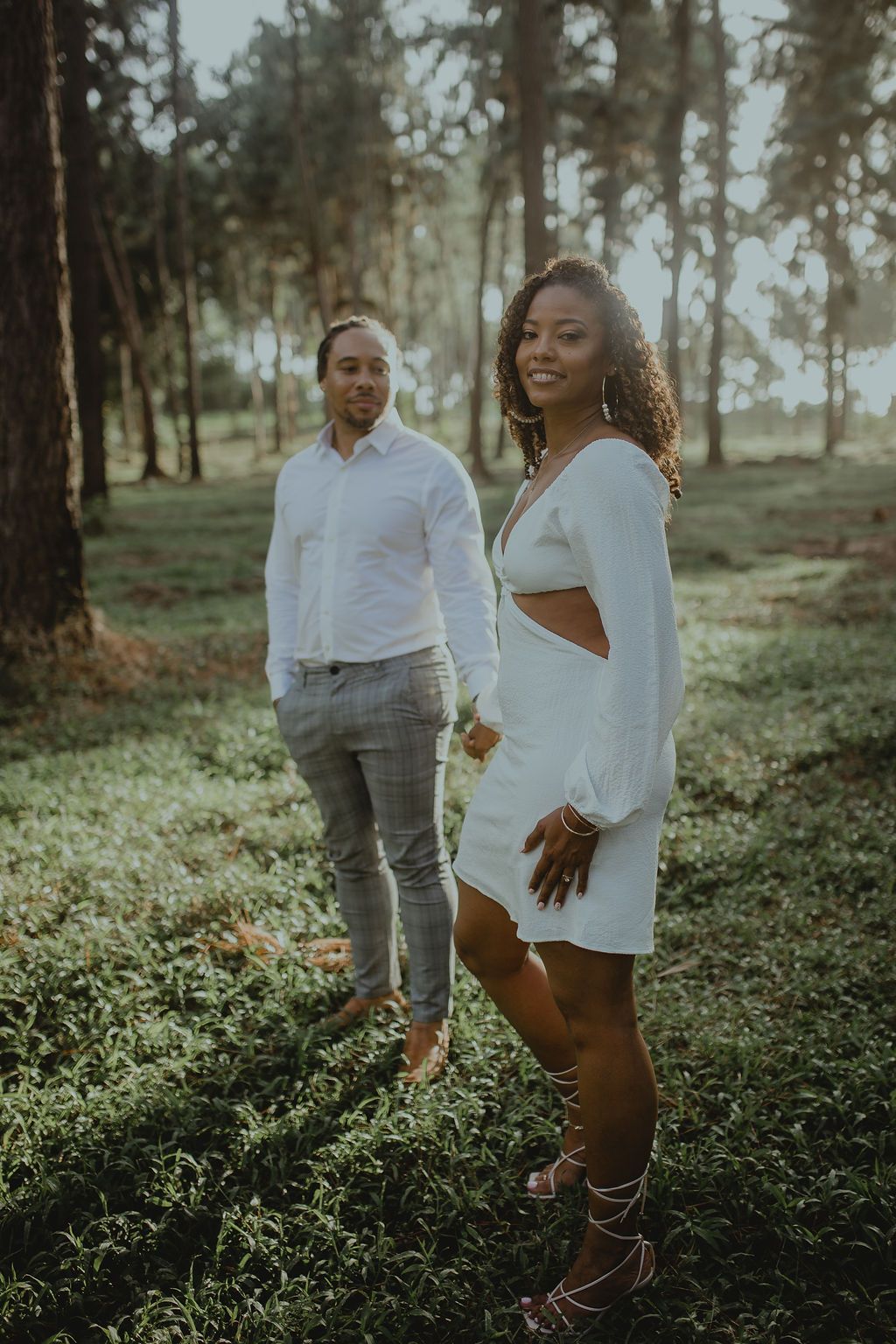 A man and a woman are standing next to each other in a field.