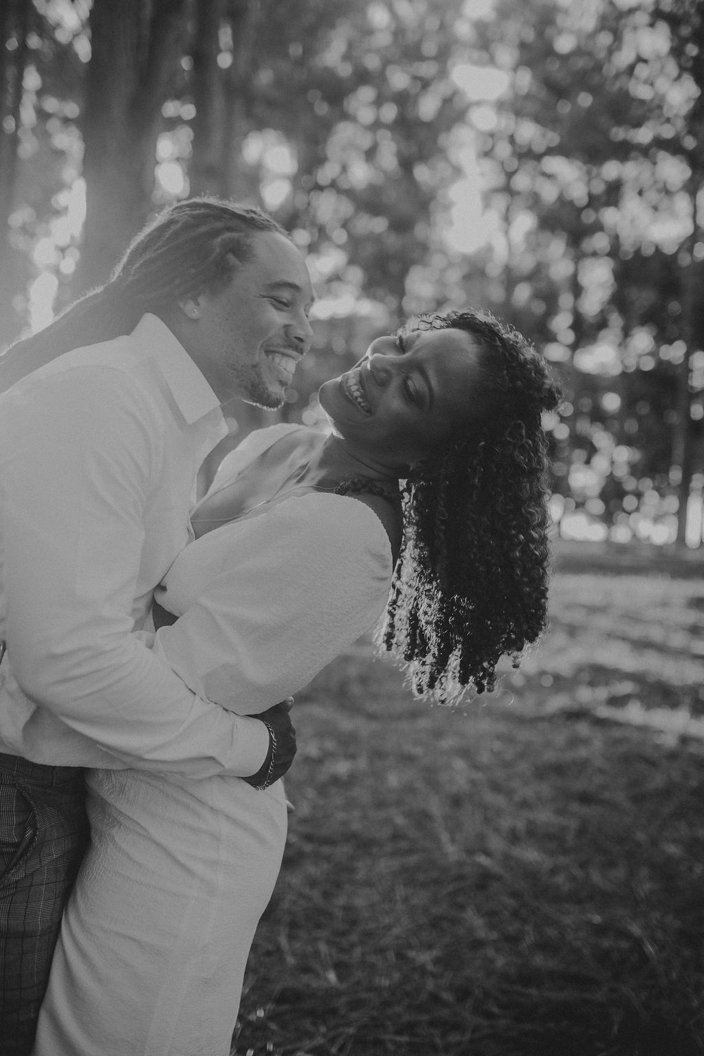 A man is holding a woman in his arms in a black and white photo.