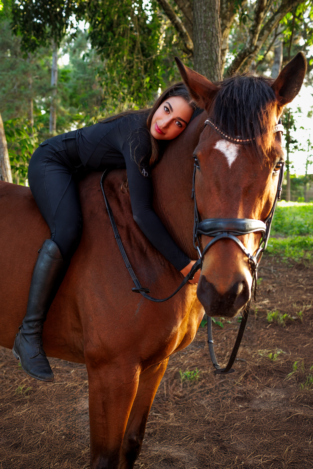 A woman is riding on the back of a brown horse.