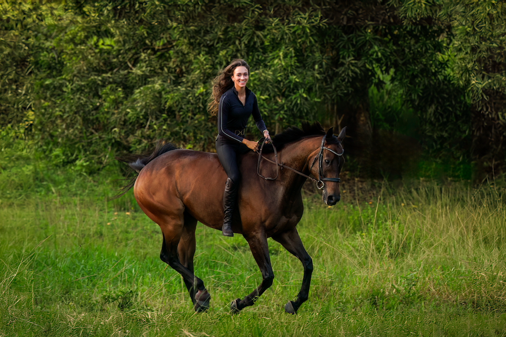 A woman is riding a brown horse in a field.