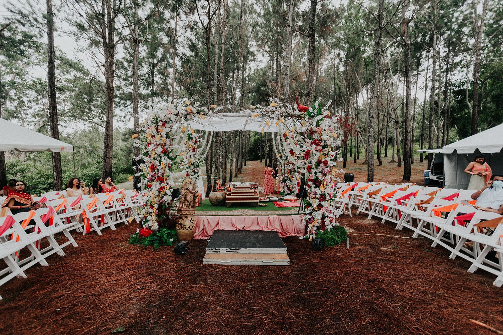 A wedding ceremony is taking place in the middle of a forest.