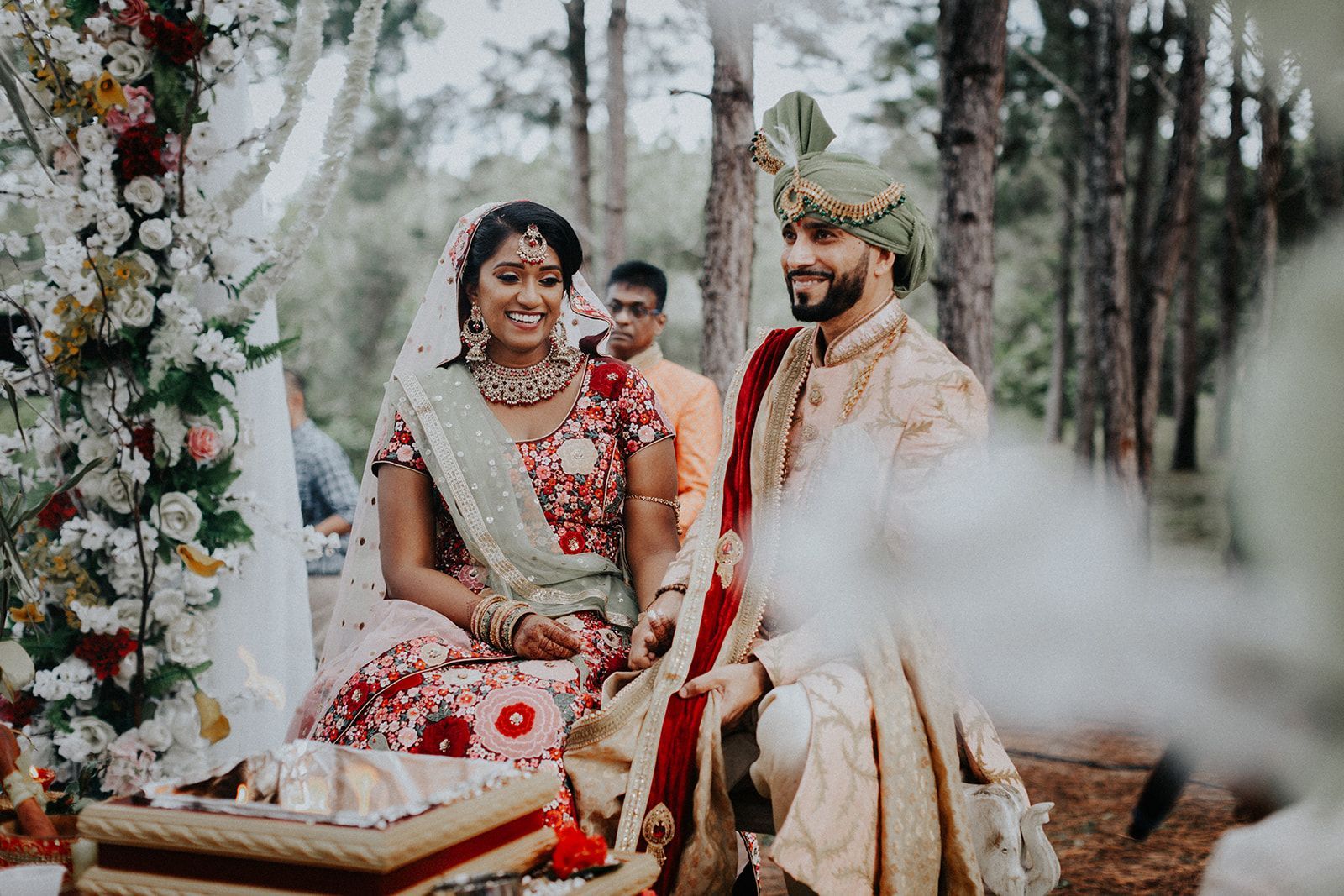 A bride and groom are sitting next to each other at their wedding ceremony.