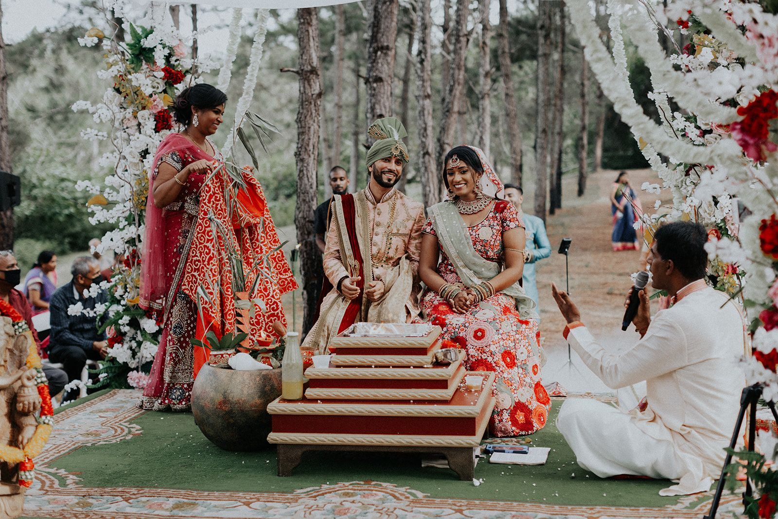 A bride and groom are sitting on a podium at their wedding ceremony.