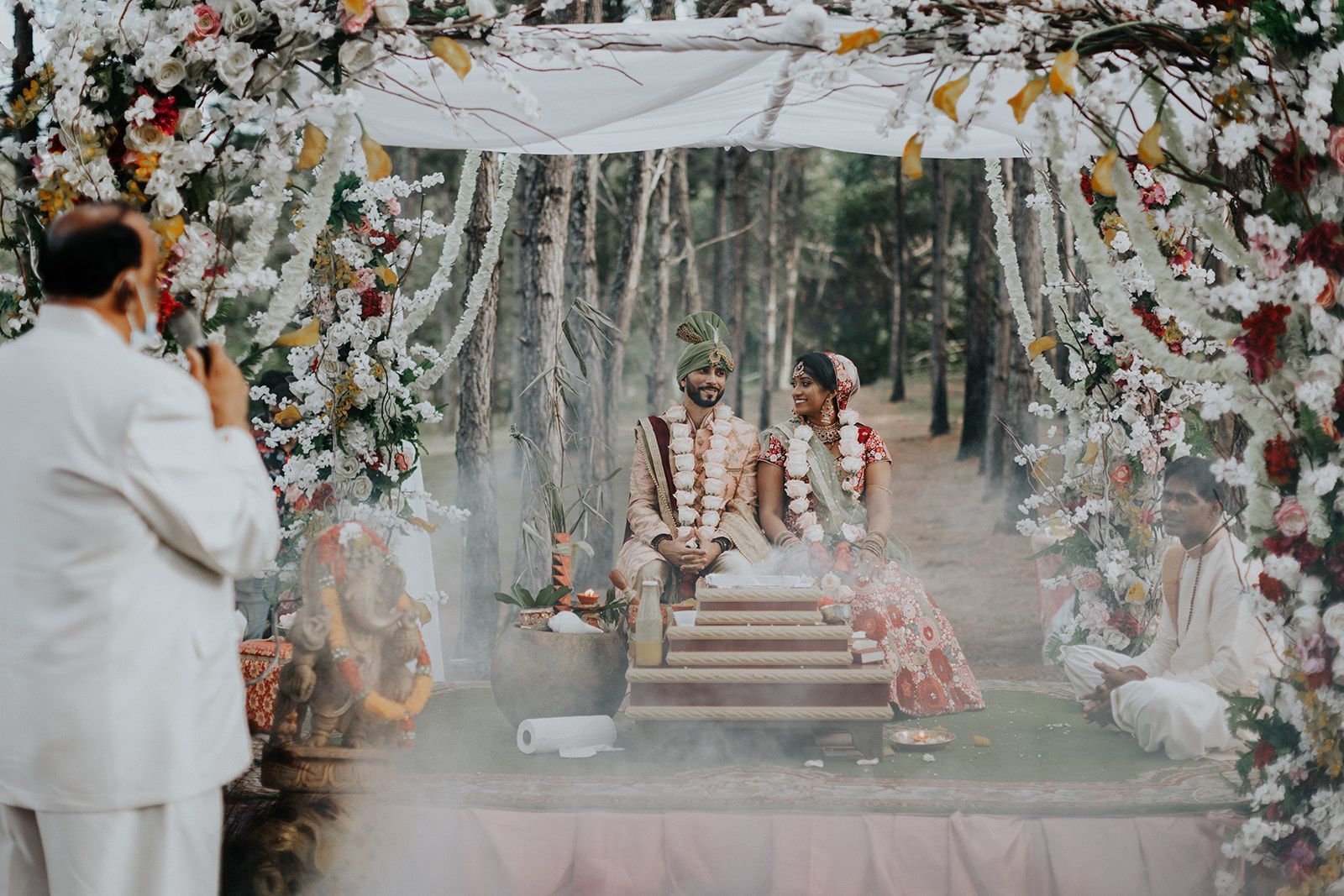 A man is taking a picture of a bride and groom during their wedding ceremony.