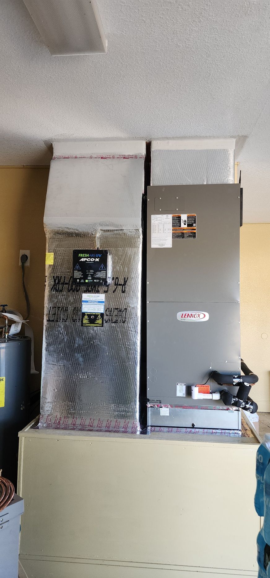 Two air conditioners are sitting next to each other in a room.