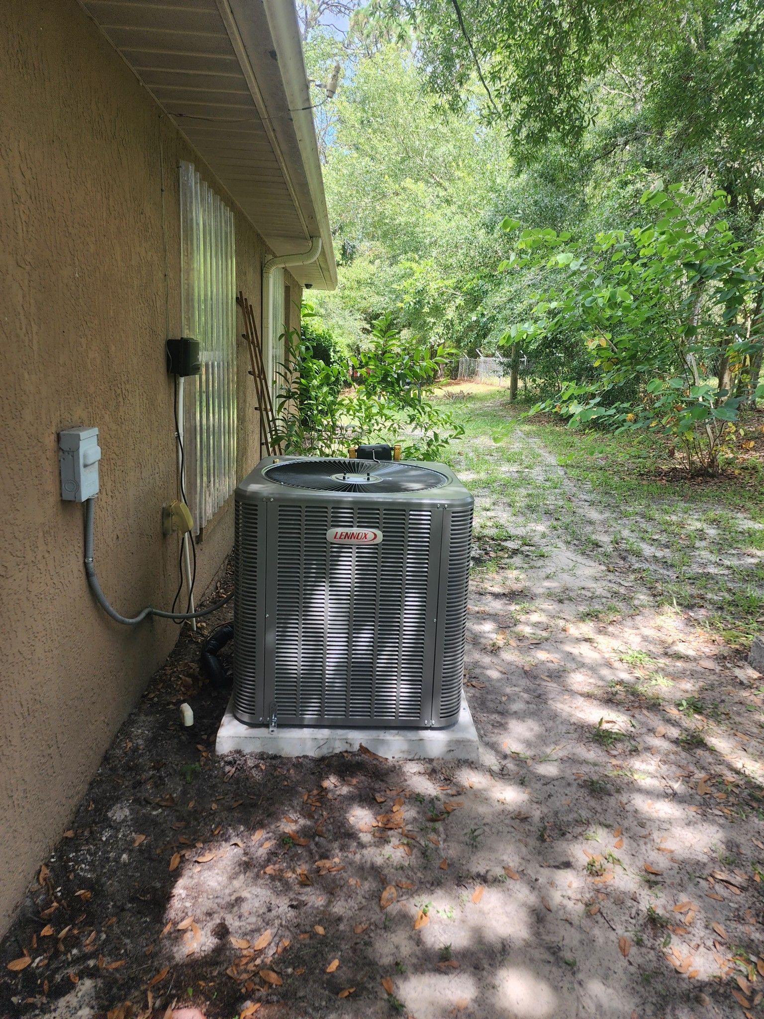 An air conditioner is sitting on the side of a house.