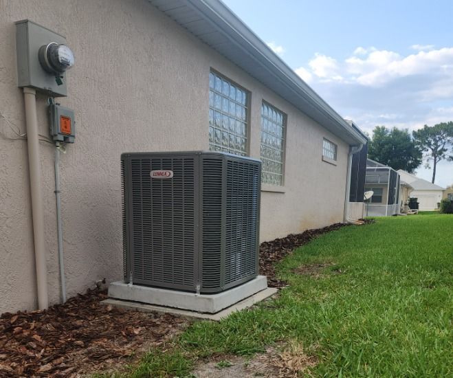 An air conditioner is sitting on the side of a house.