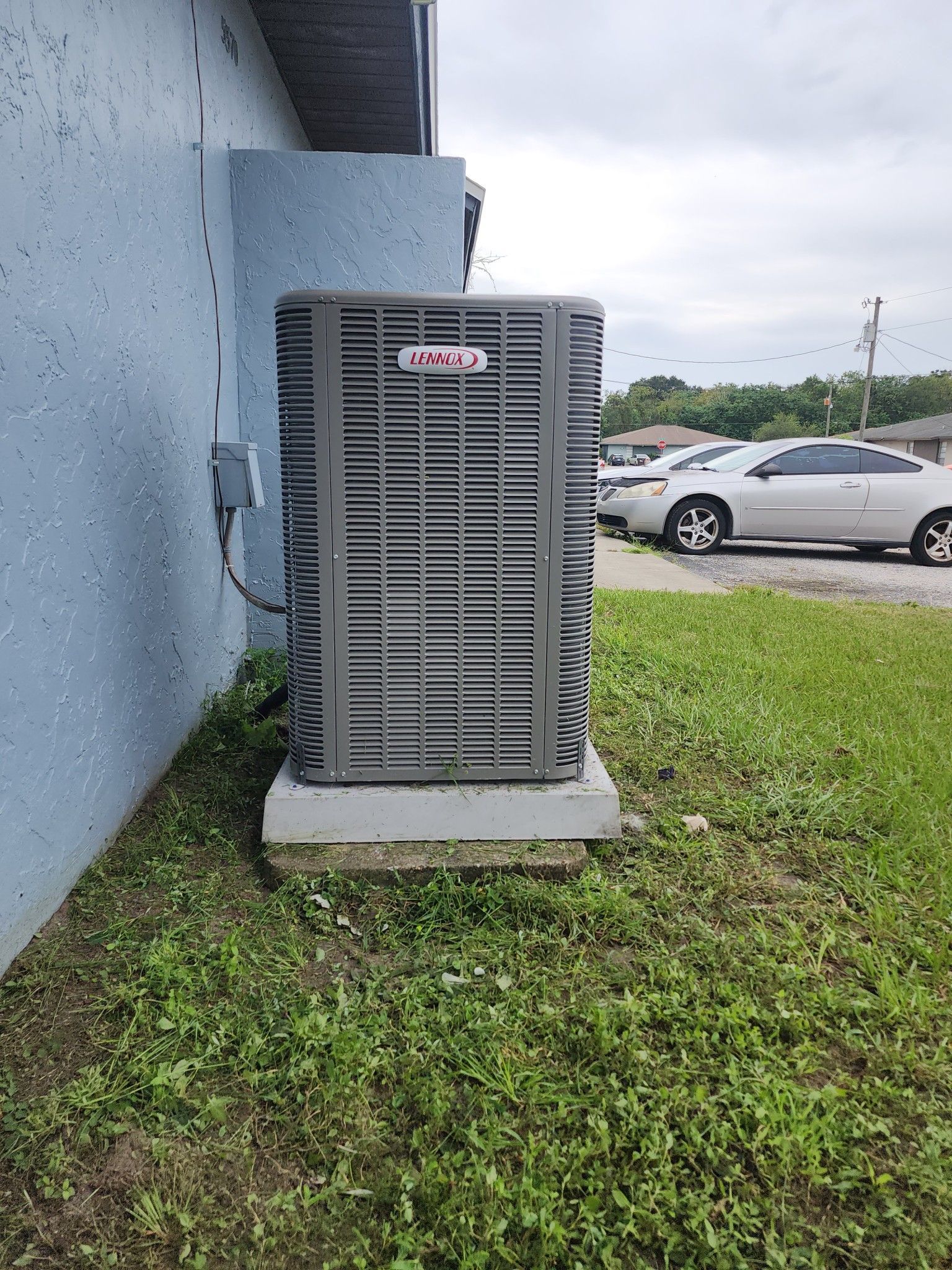 A large air conditioner is sitting on the side of a building.