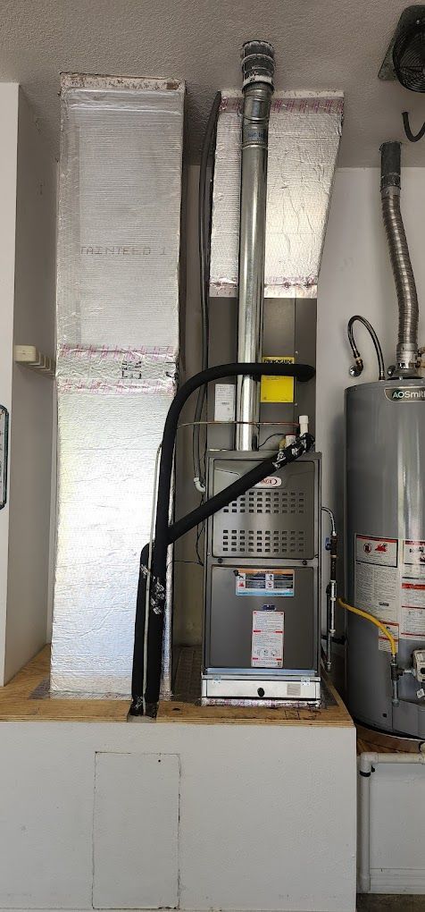 A gas heater is sitting next to a water heater in a room.