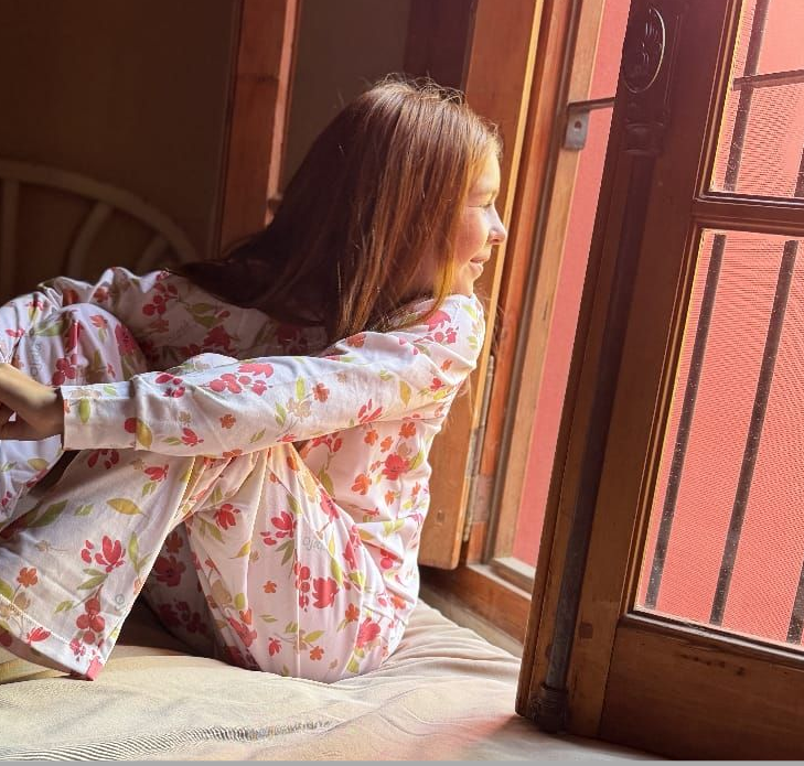 Patrón floral de acuarela con flores rojas, naranjas y amarillas y hojas verdes sobre un fondo blanco.