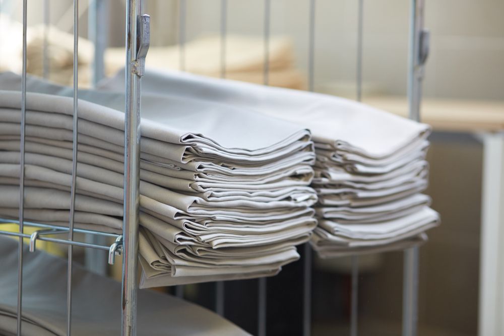 A Stack Of Towels Is Sitting On Top Of A Metal Rack — Tanilba Bay Laundromat In Tanilba Bay, NSW