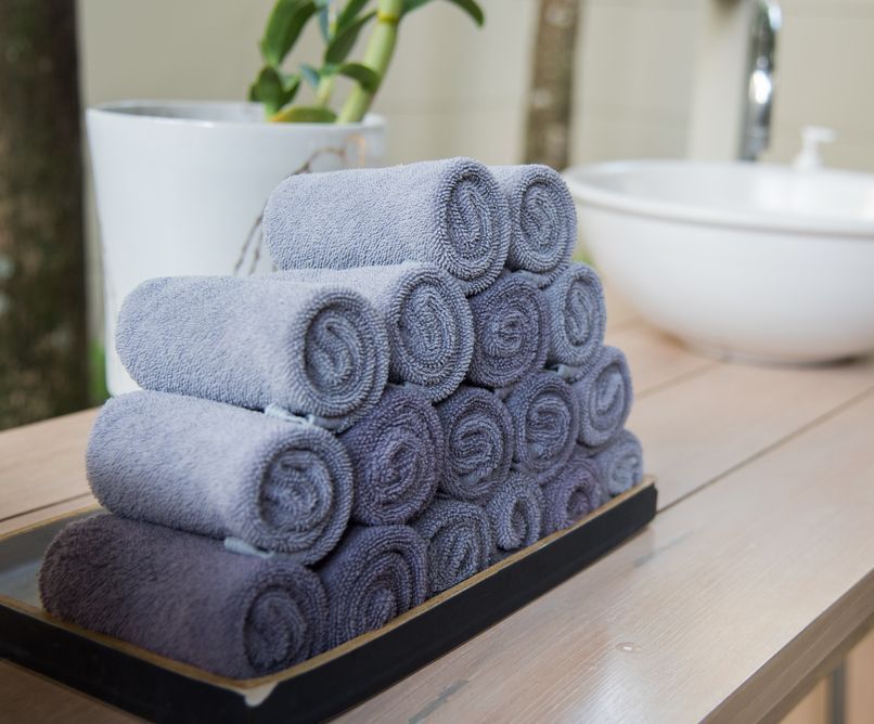 A Bunch Of Towels Are Stacked On Top Of Each Other On A Table — Tanilba Bay Laundromat In Anna Bay, NSW