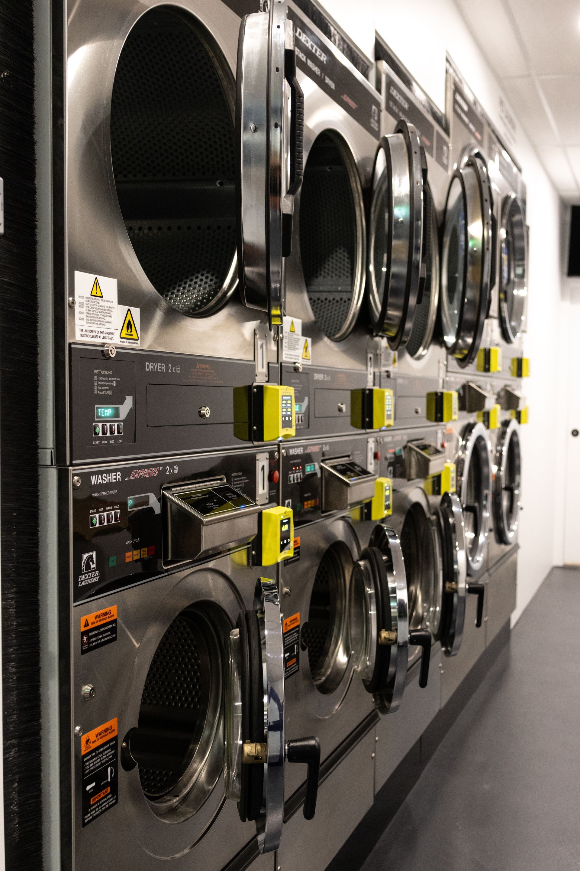 A row of washing machines are lined up in a laundromat — Tanilba Bay Laundromat In Tanilba Bay, NSW