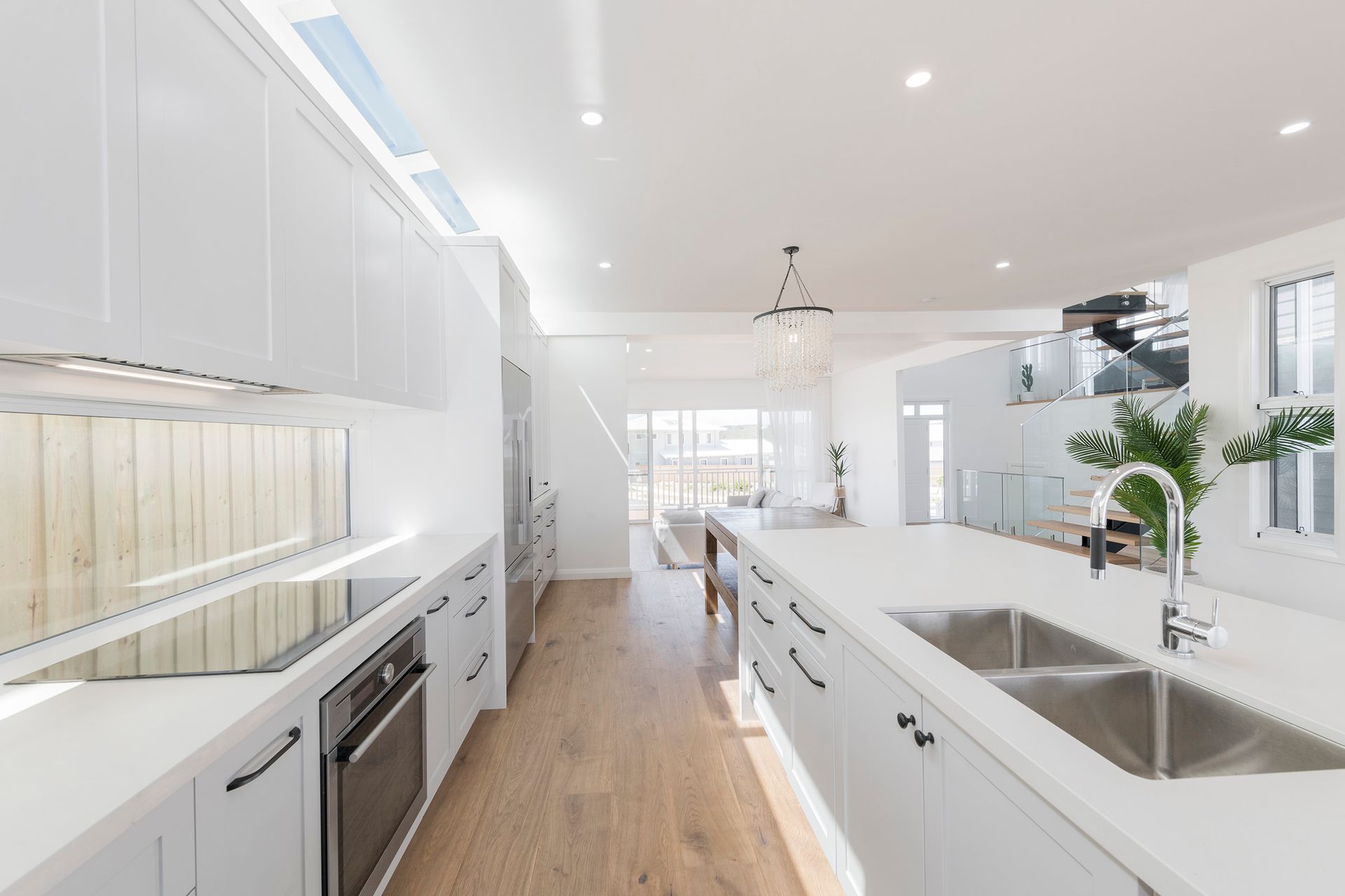 Bright White Modern Kitchen With Large Island, Steel Sink, and Light Wood Floors — Indie Living In Lake Macquarie, NSW