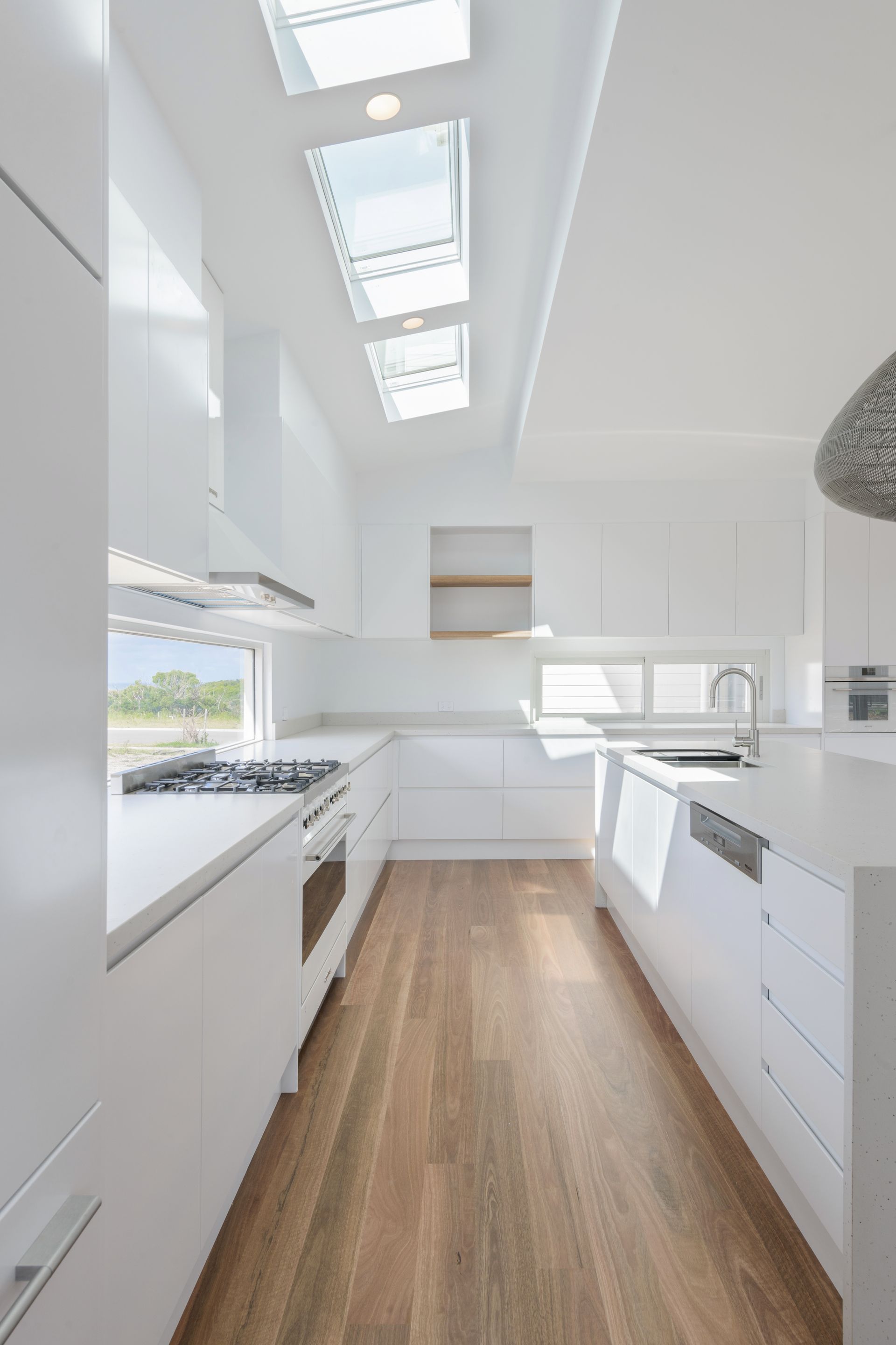 Bright White Modern Kitchen With Skylights, White Cabinets, Light Wood Floor — Indie Living In Lake Macquarie, NSW