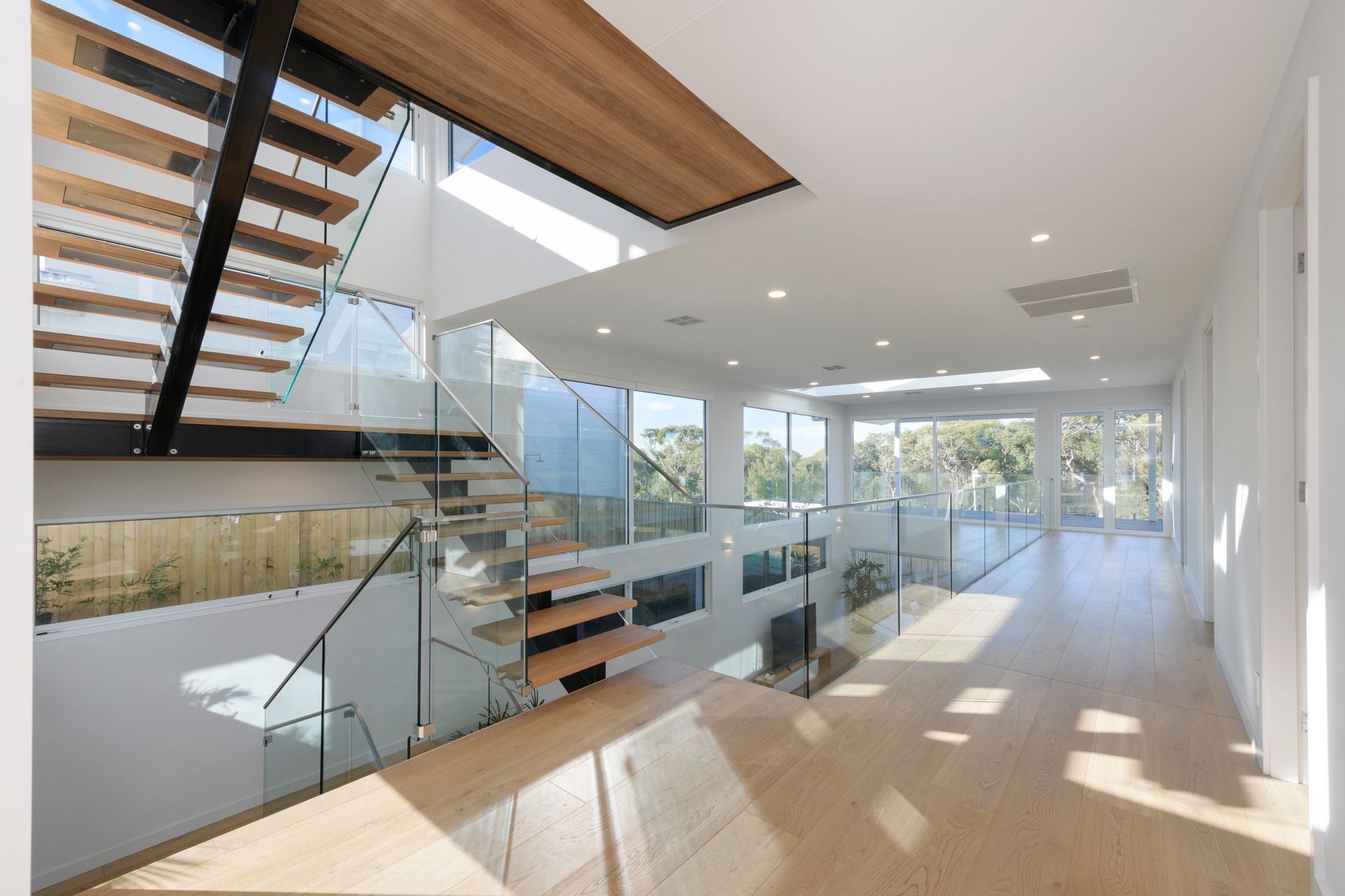 Modern Home Interior With Wooden Stairs, Glass Railings, and a Bright, Airy Hallway — Indie Living In Lake Macquarie, NSW