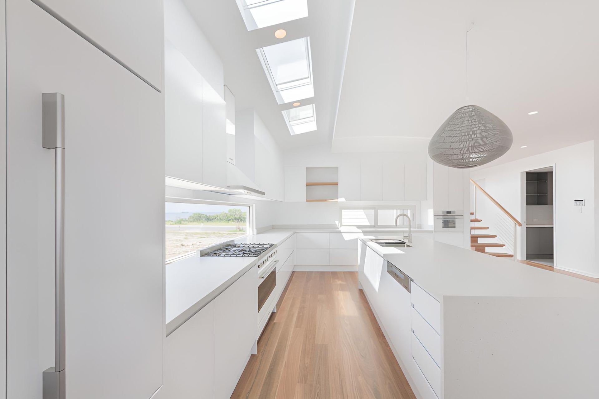 A Kitchen With White Cabinets and Wooden Floors in a House — Indie Living In Bennetts Green, NSW