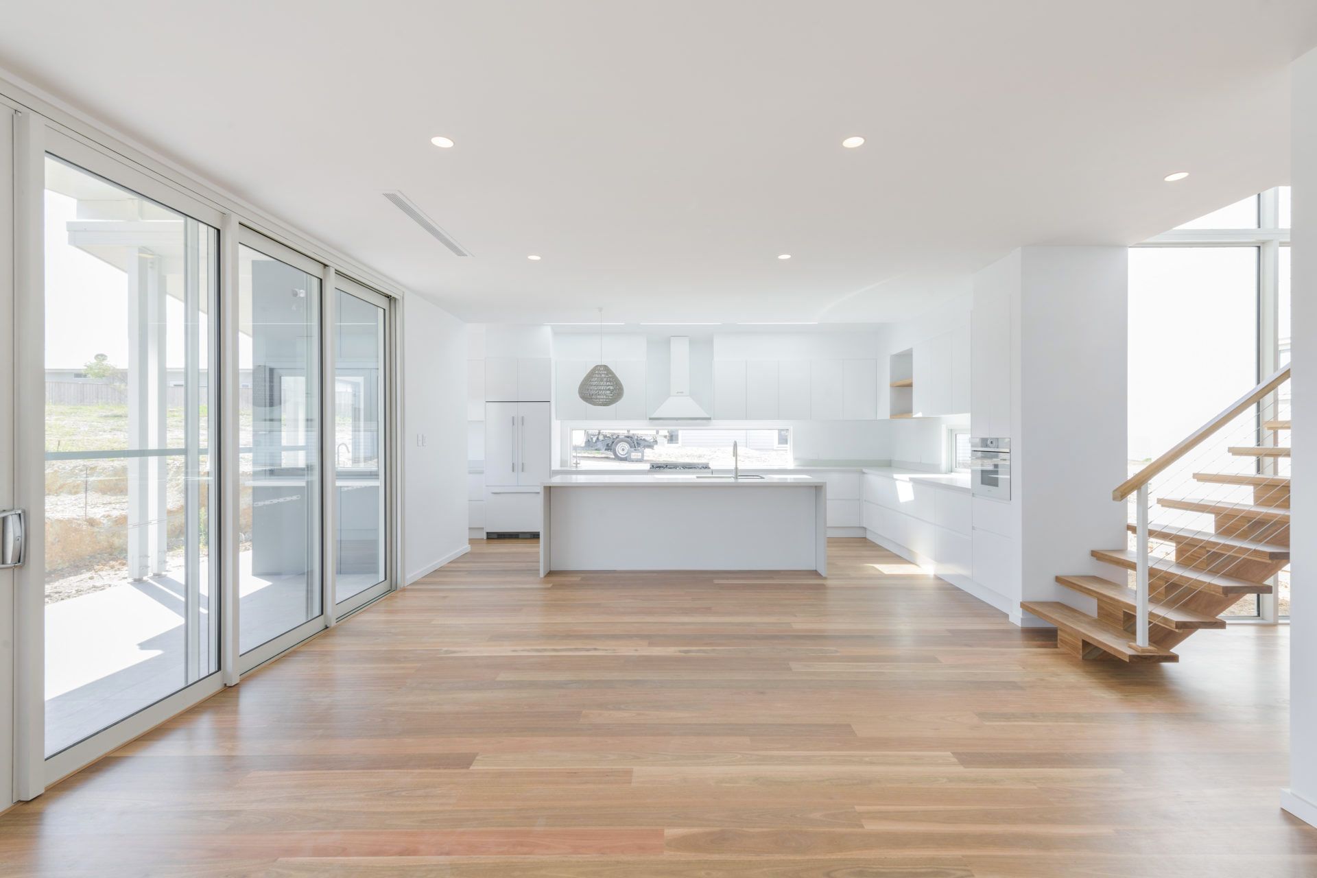 An Empty Kitchen With a Wooden Floor and Stairs — Indie Living In Bennetts Green, NSW