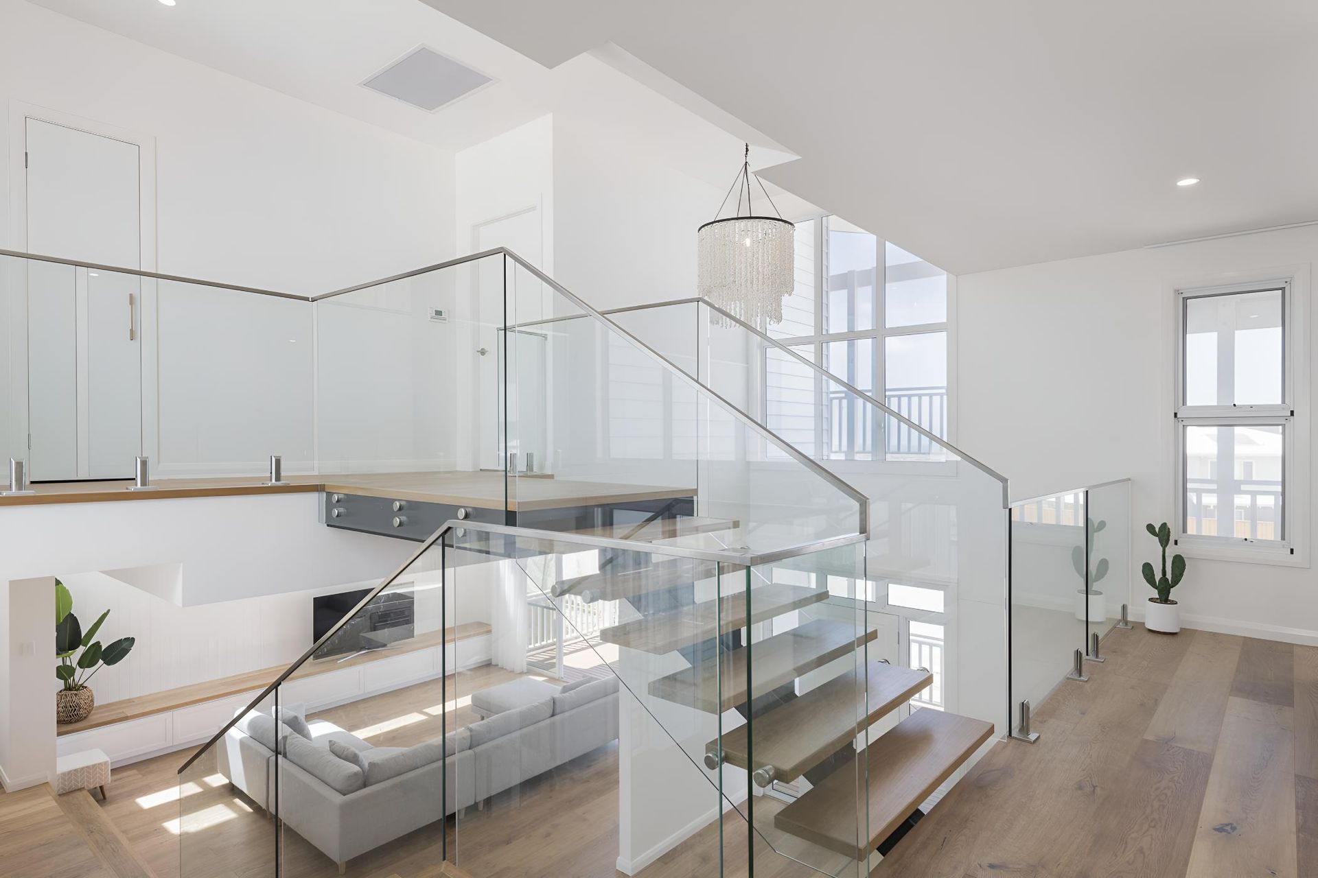 A Living Room With a Staircase and a Glass Railing — Indie Living In Bennetts Green, NSW