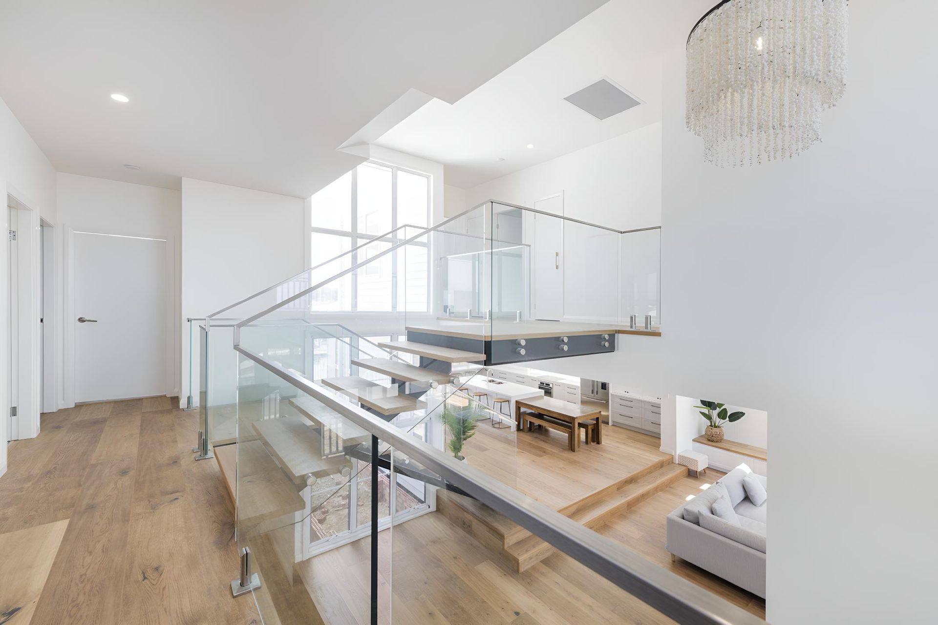 A Staircase With a Glass Railing Leading to the Second Floor of a House — Indie Living In Bennetts Green, NSW