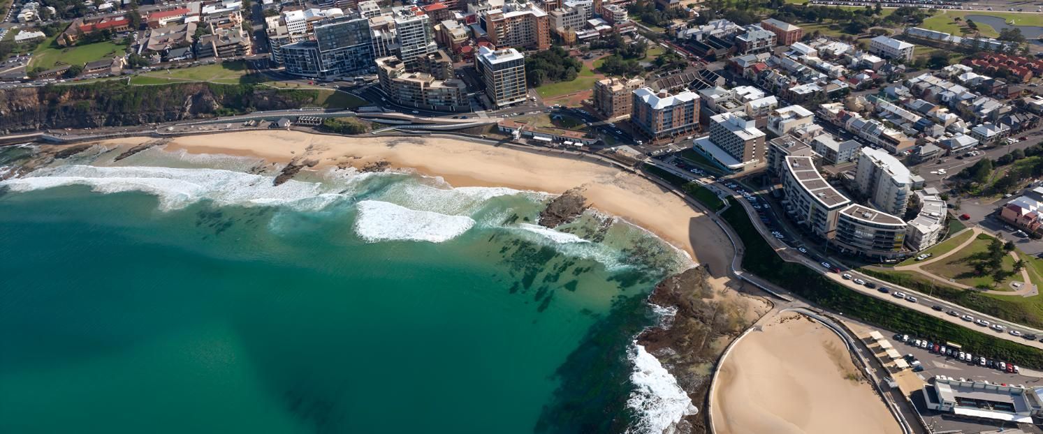 An Aerial View of a Beach With a City in the Background — Indie Living In Bennetts Green, NSW