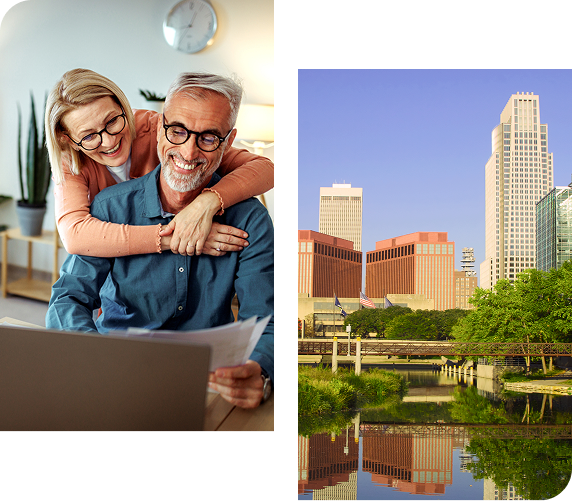 Couple reviewing paperwork, smiling, with a city skyline reflected in water.
