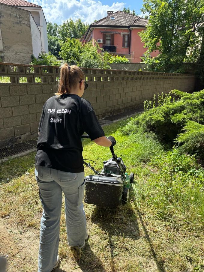 Corridoio interno vuoto con pavimento in legno lucido, pareti bianche, una grande colonna e una pianta vicino a una porta chiusa.