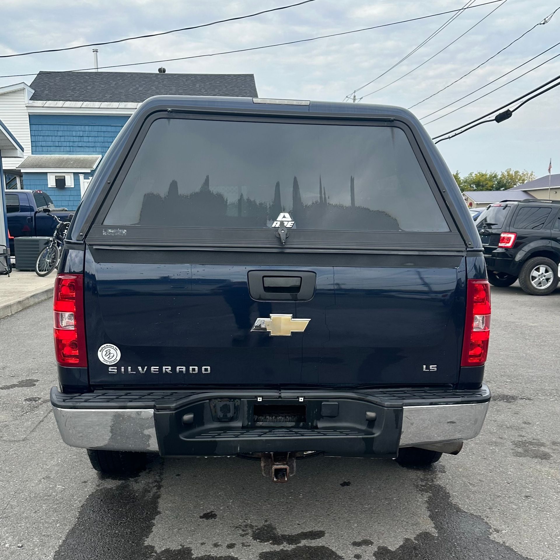 A blue chevrolet silverado truck is parked in a parking lot.