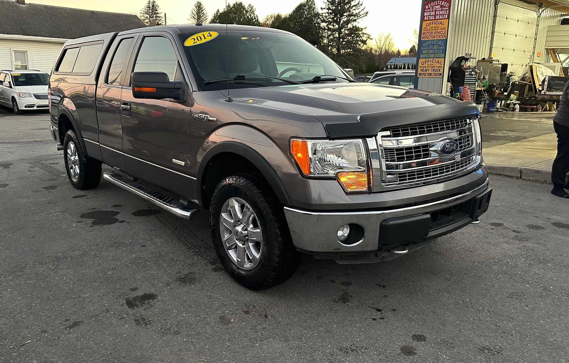 A gray ford f150 truck is parked in a parking lot.