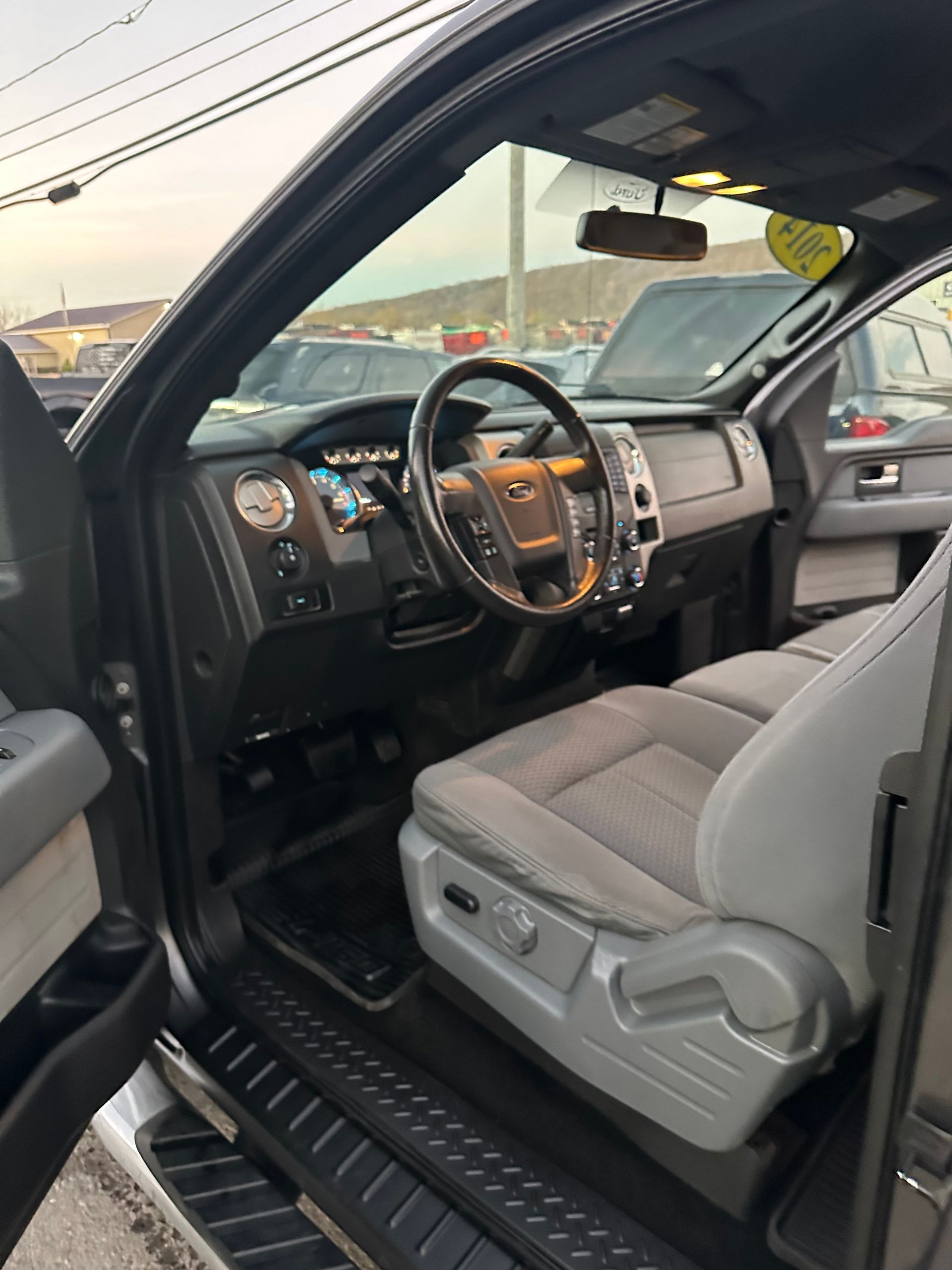 The interior of a ford f150 truck with the door open.