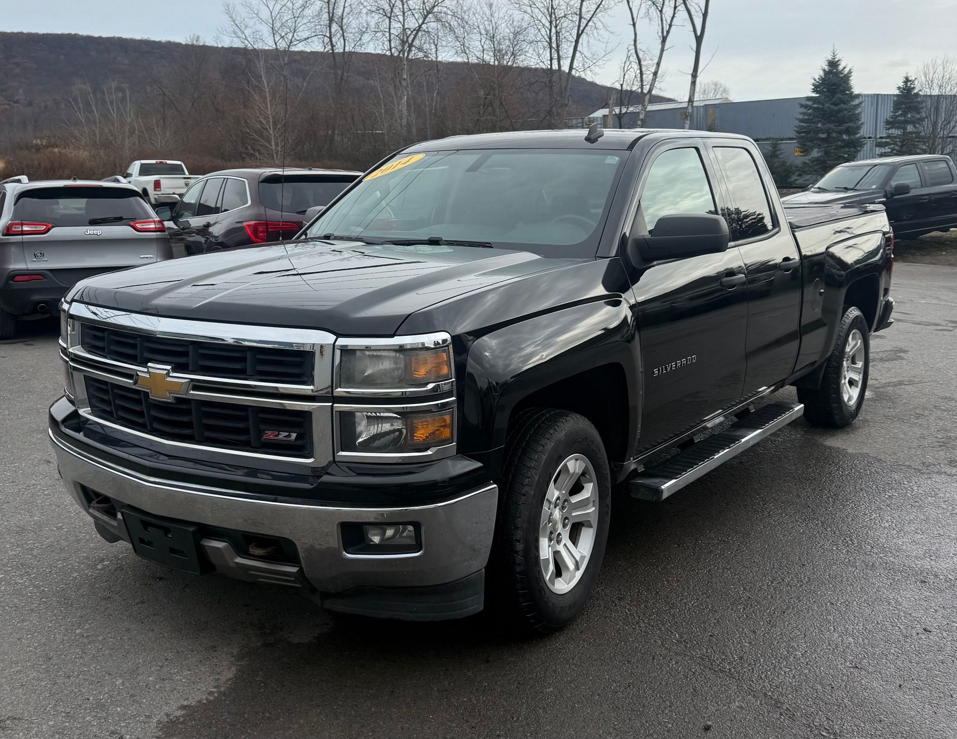 Black Chevy Silverado pickup truck parked on asphalt lot.