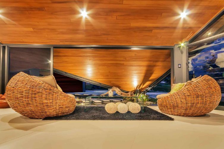Two Wicker Chairs Are Sitting in a Living Room With a Wooden Ceiling — Omni Builders In Bungalow, QLD