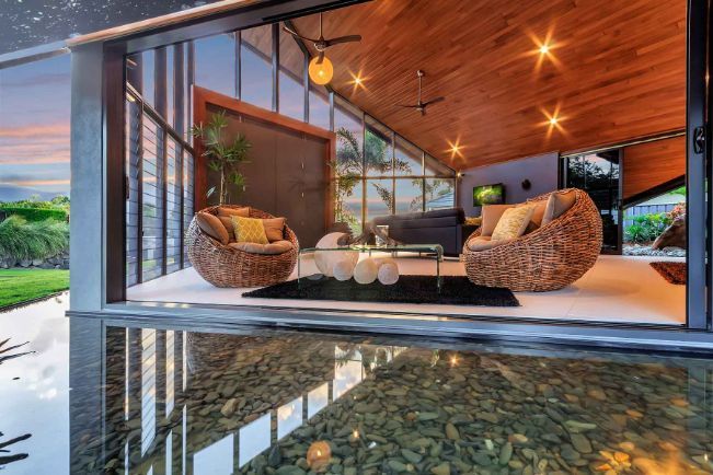 A Living Room With a Lot of Windows and Chairs — Omni Builders In Bungalow, QLD