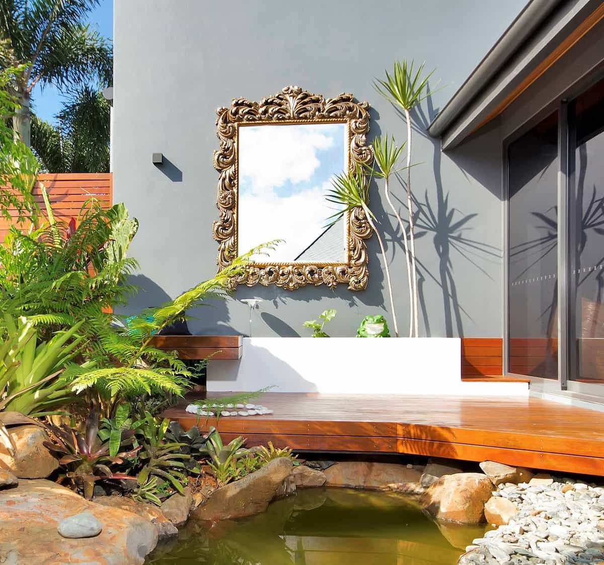 A Mirror Hangs On A Wall Above A Pond — Omni Builders In Bungalow, QLD