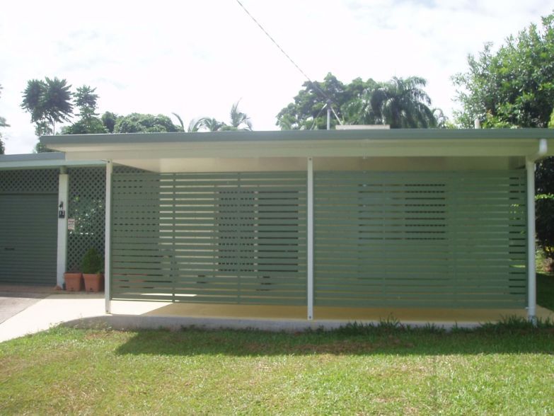 A Green House With a Porch and Shutters on the Windows — Omni Builders In Bungalow, QLD