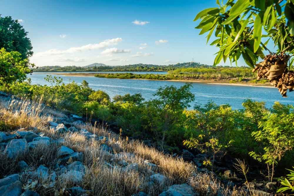 A Large Body Of Water Surrounded By Trees And Rocks — Omni Builders In Redlynch, QLD
