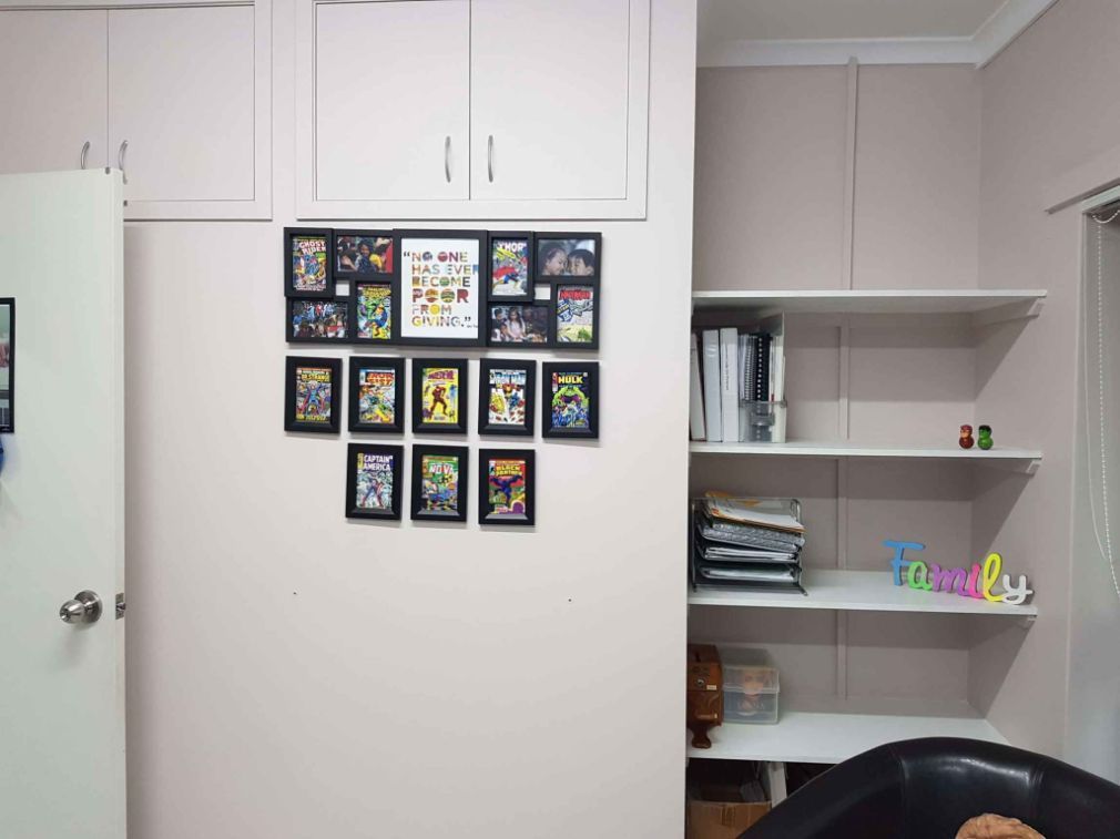 A Room With a Lot of Pictures on the Wall and a Sign That Says Family — Omni Builders In Bungalow, QLD