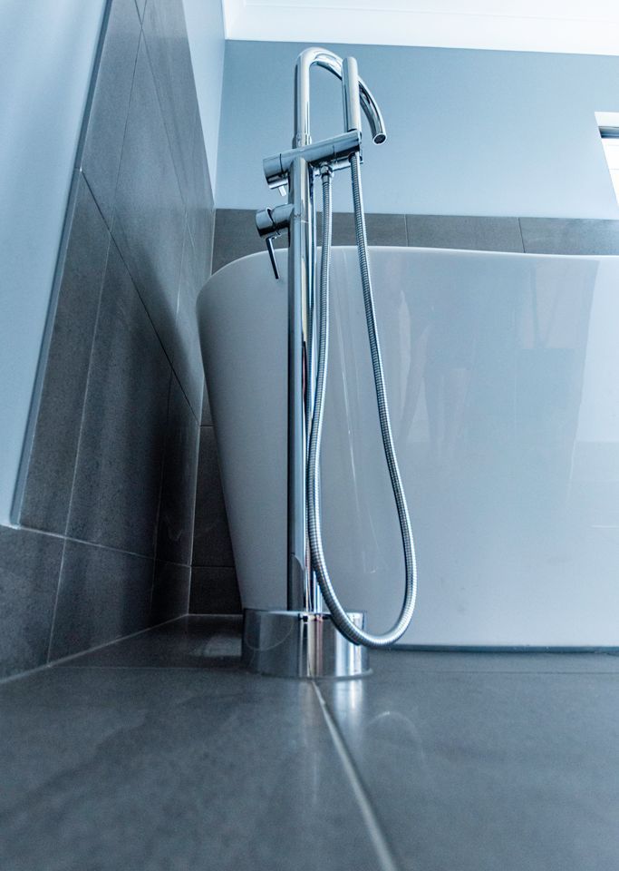 A Bathroom With a Bathtub and a Sink With a Hose Attached to It — Omni Builders In Bungalow, QLD