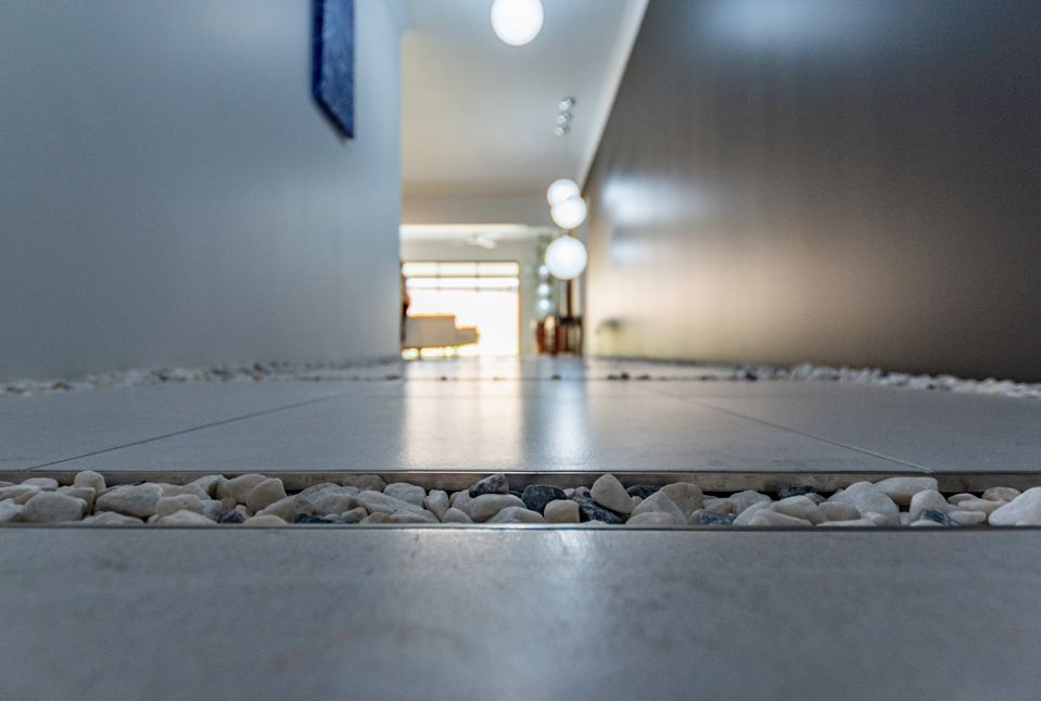A Hallway With a Tiled Floor and Rocks on the Floor — Omni Builders In Bungalow, QLD