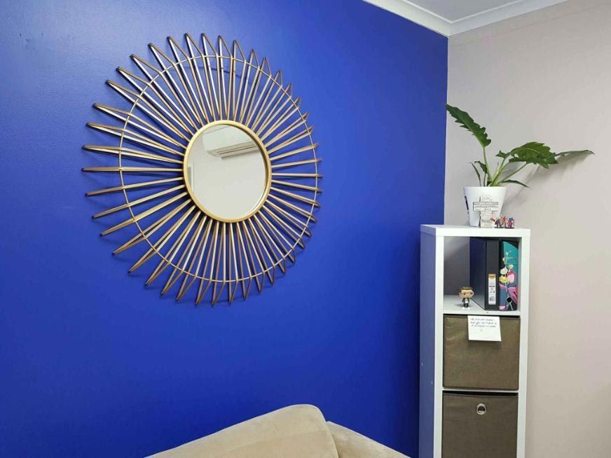A Living Room With A Blue Wall And Couch — Omni Builders In Bungalow, QLD